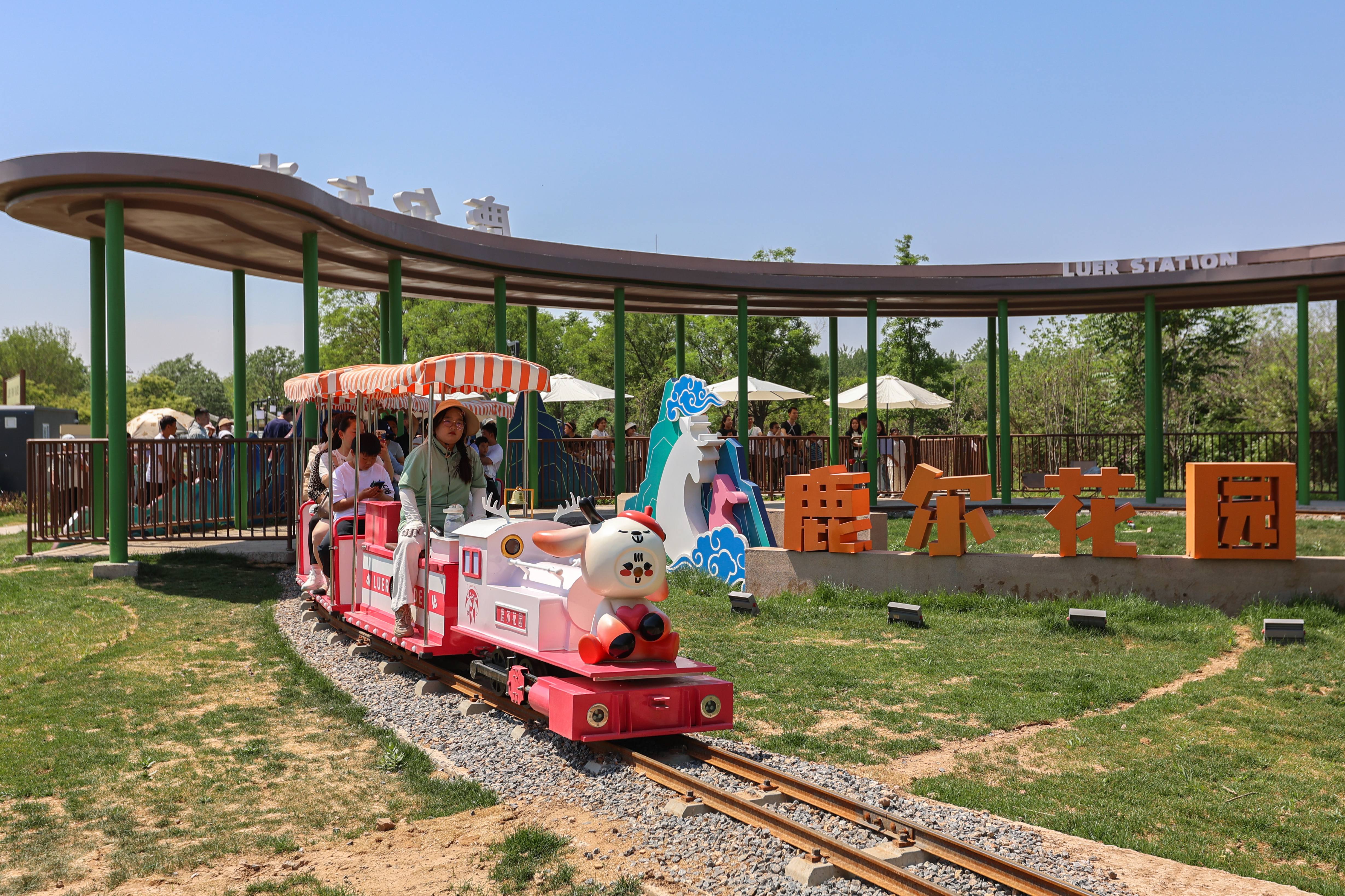 游客在邯鄲趙王城鹿爾花園乘坐小火車游玩。李燊攝