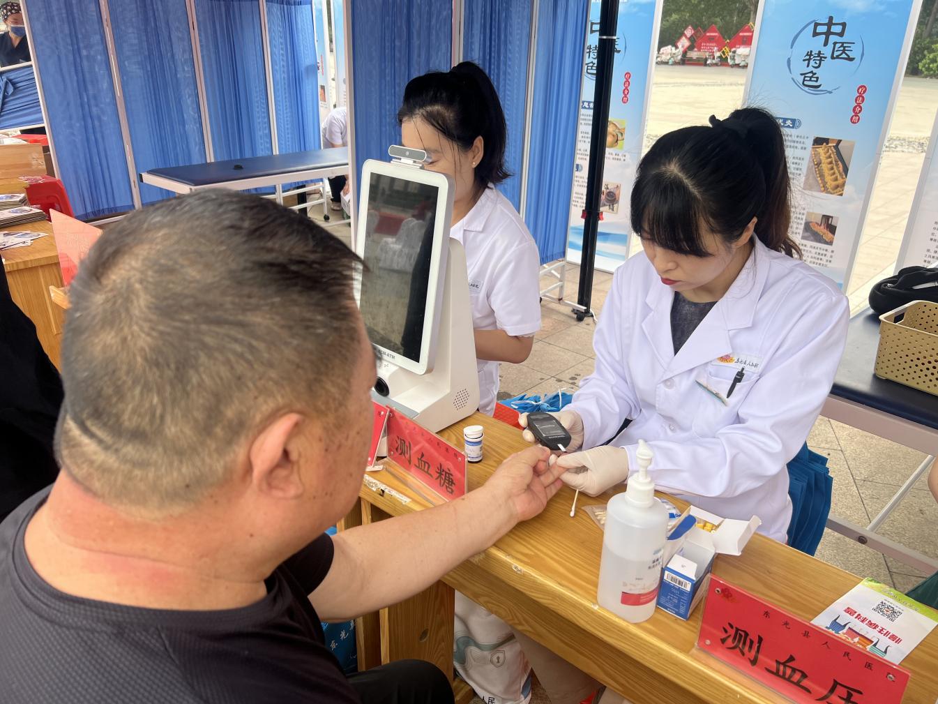 医务人员为群众检测血糖。刘刚摄