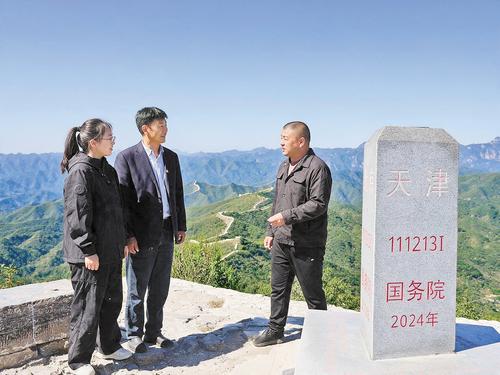 10月1日，北京市平谷區金海湖鎮紅石門村黨支部書記胡杰（左）、天津市薊州區下營鎮前干澗村黨支部書記張雪鬆（中）和河北省興隆縣陡子峪鄉前干澗村黨支部書記閆鳳龍在京津冀三界碑旁相聚，共同商量三個村怎樣抱團發展得更紅火。河北日報見習記者 崔玉潔攝