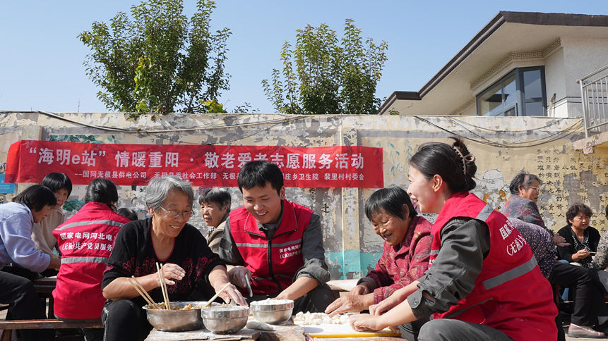 国网无极县供电公司志愿服务者依托“海明e站”与老人欢聚一堂、包饺子话家常。仝云涛摄