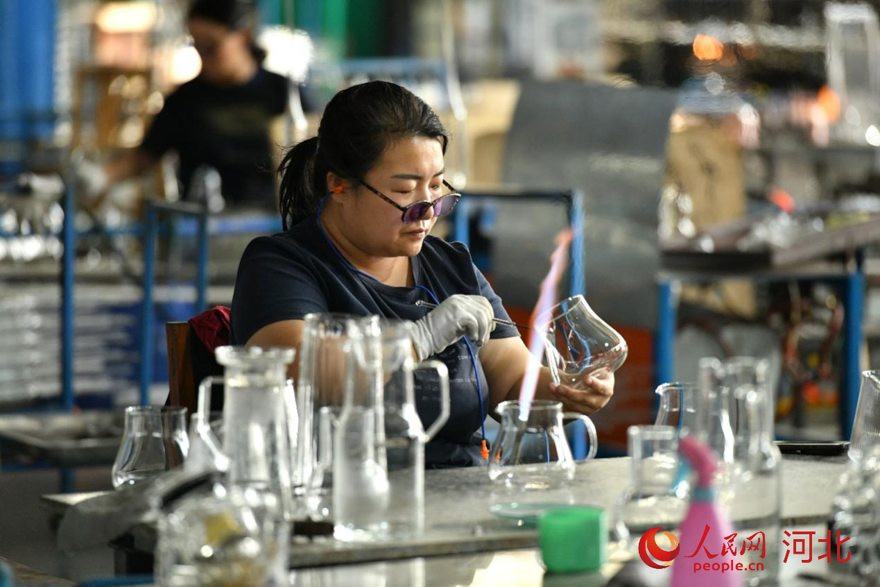 工人在位于河北沧州河间市的河北明尚德玻璃科技股份有限公司生产车间内制作工艺玻璃制品。人民网记者 方童摄